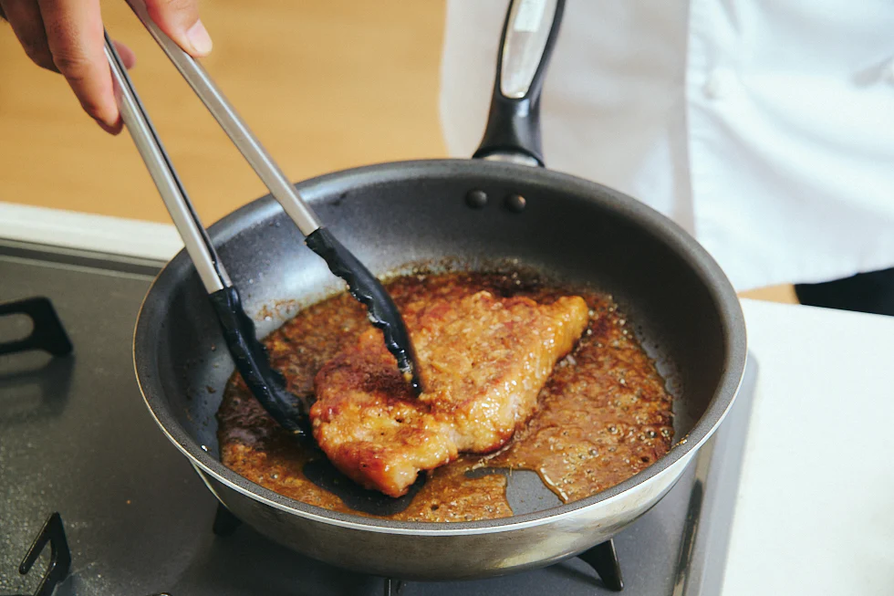 肉にタレを絡めている様子