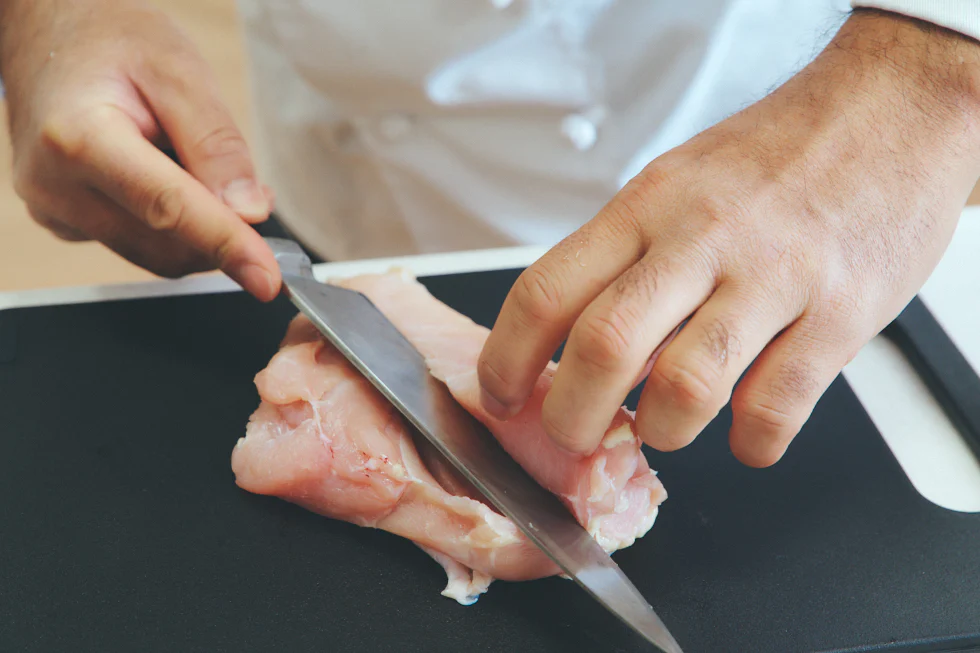 肉の中央部分に包丁を入れ、刃を左側に向かって寝かせながら切り進める