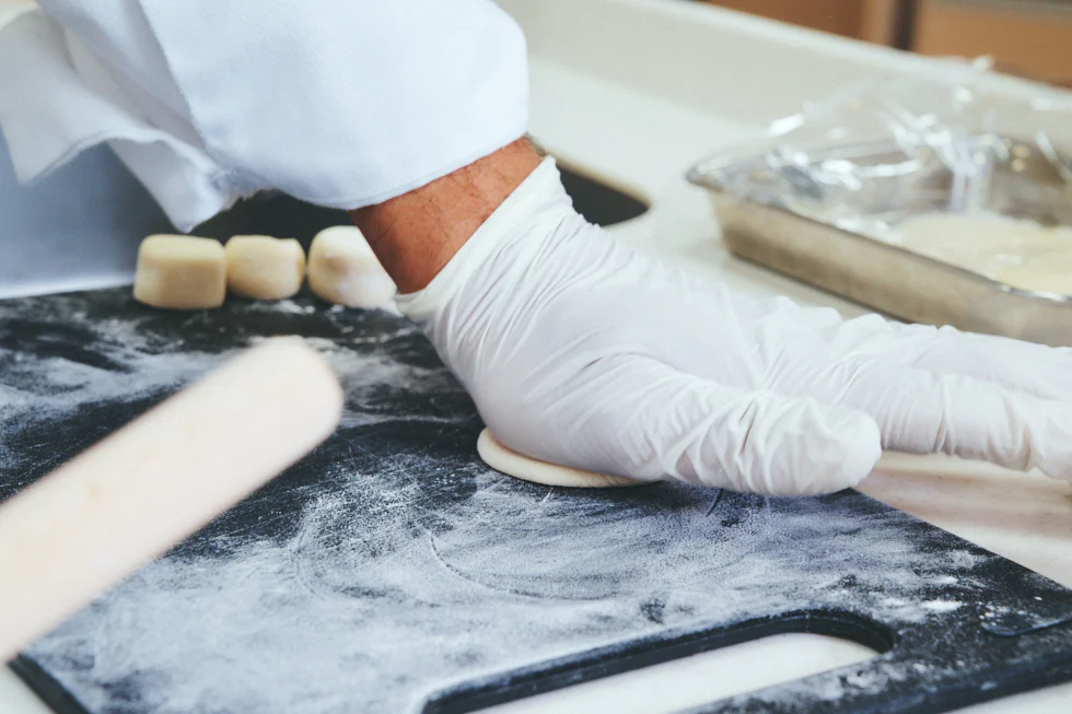 等分した餃子の皮を平らにし、めん棒で伸ばす。