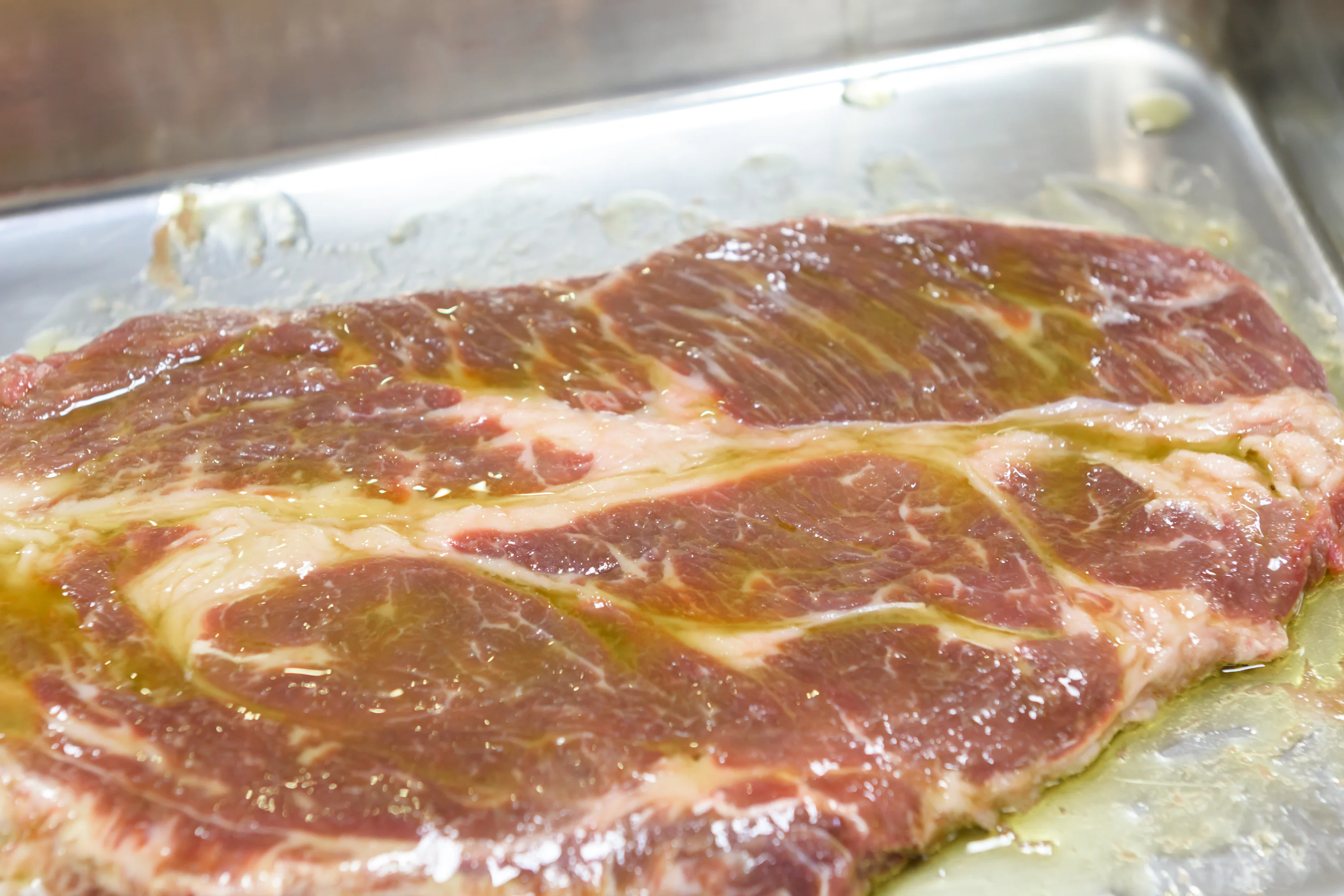 肉にオリーブオイルが塗られている様子