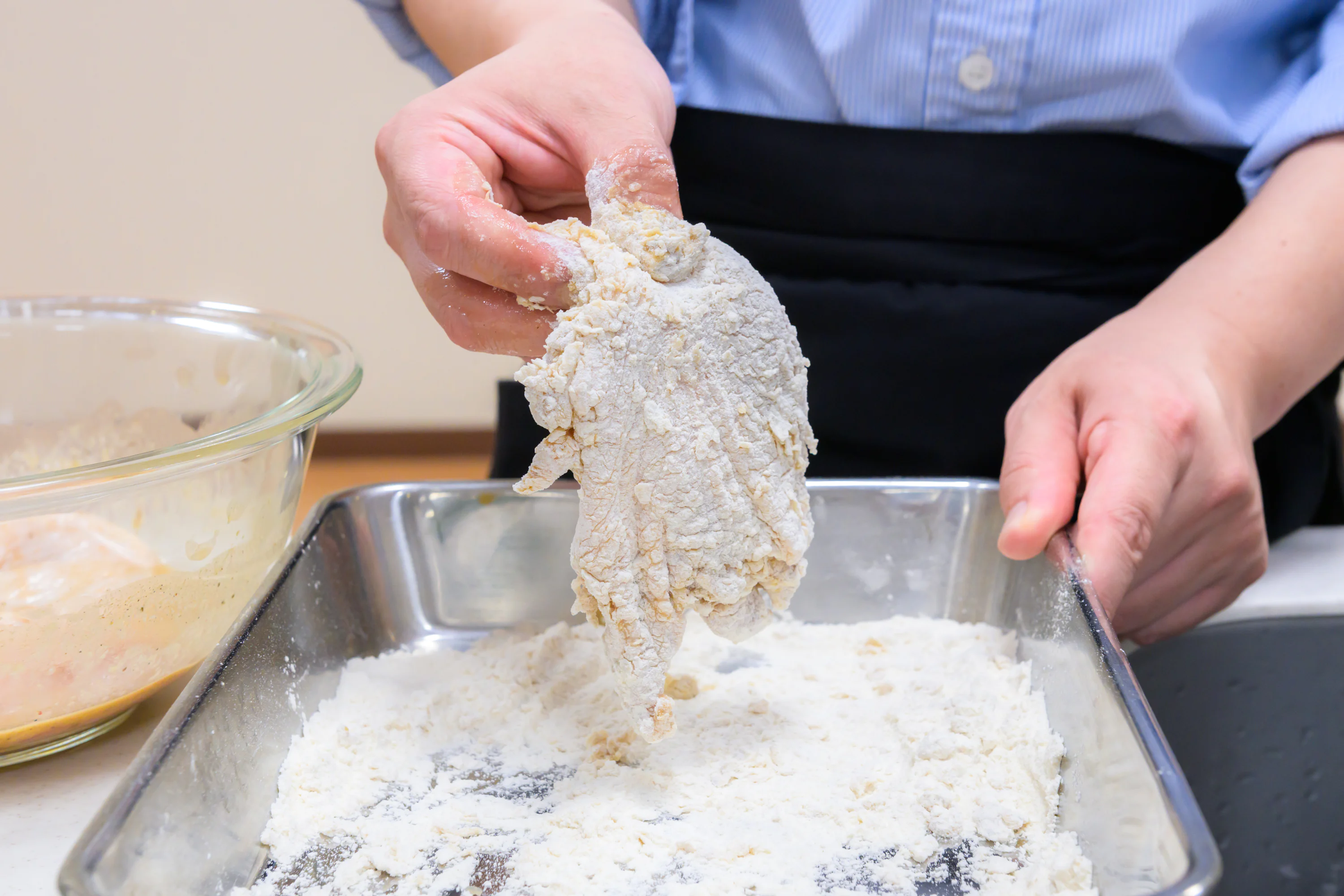 鶏肉に衣の粉をつけている様子
