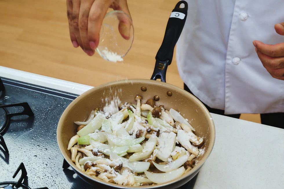 野菜に油がまわりツヤが出たら、小麦粉を加えます