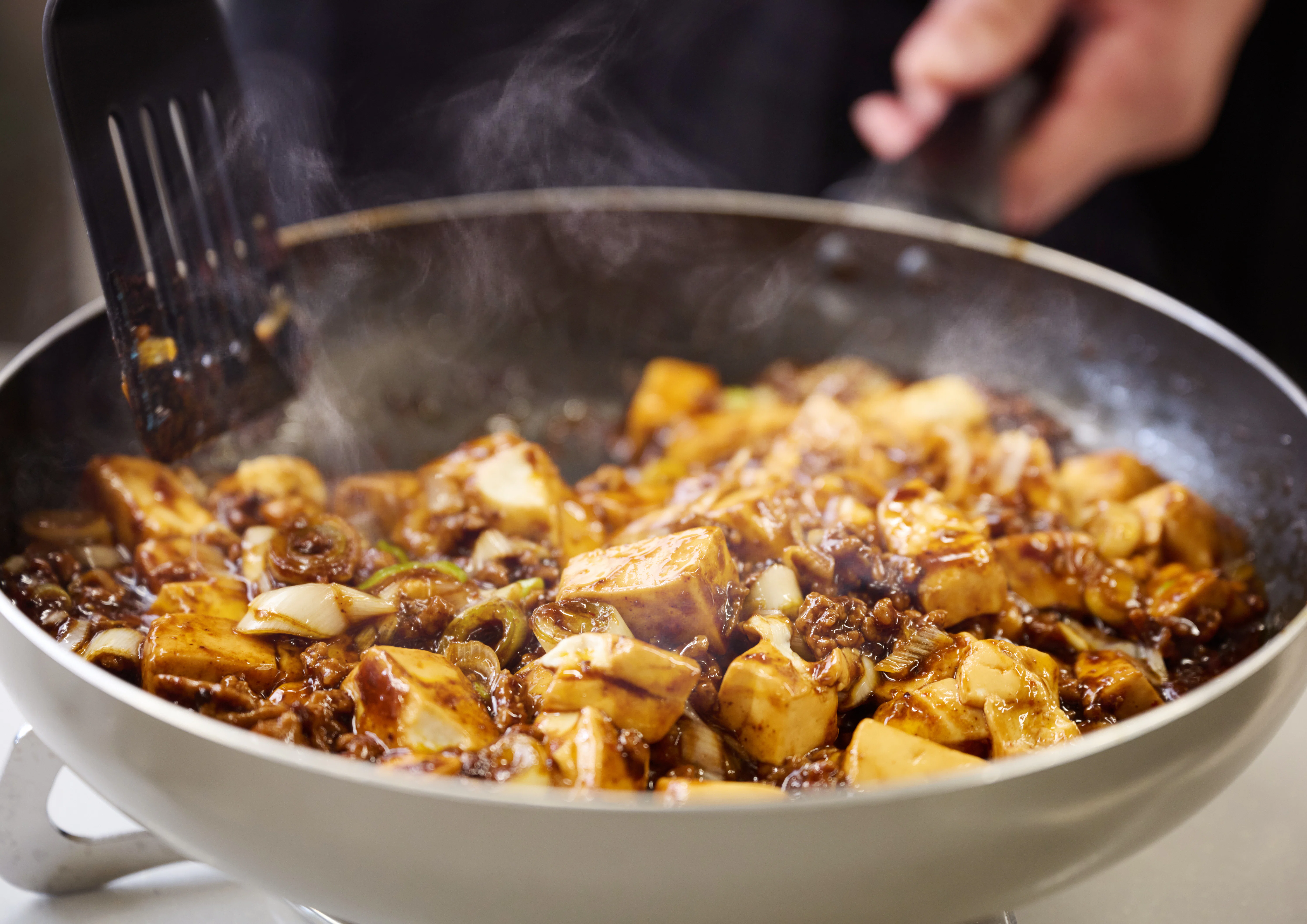 麻婆豆腐をフライパンを使って調理する様子