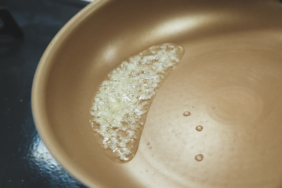 フライパンに油とにんにくを入れて弱火で熱し、香りを油に移す。にんにくは包丁の腹でつぶしてからみじん切りにすると、細胞が壊れて香りが出やすくなる