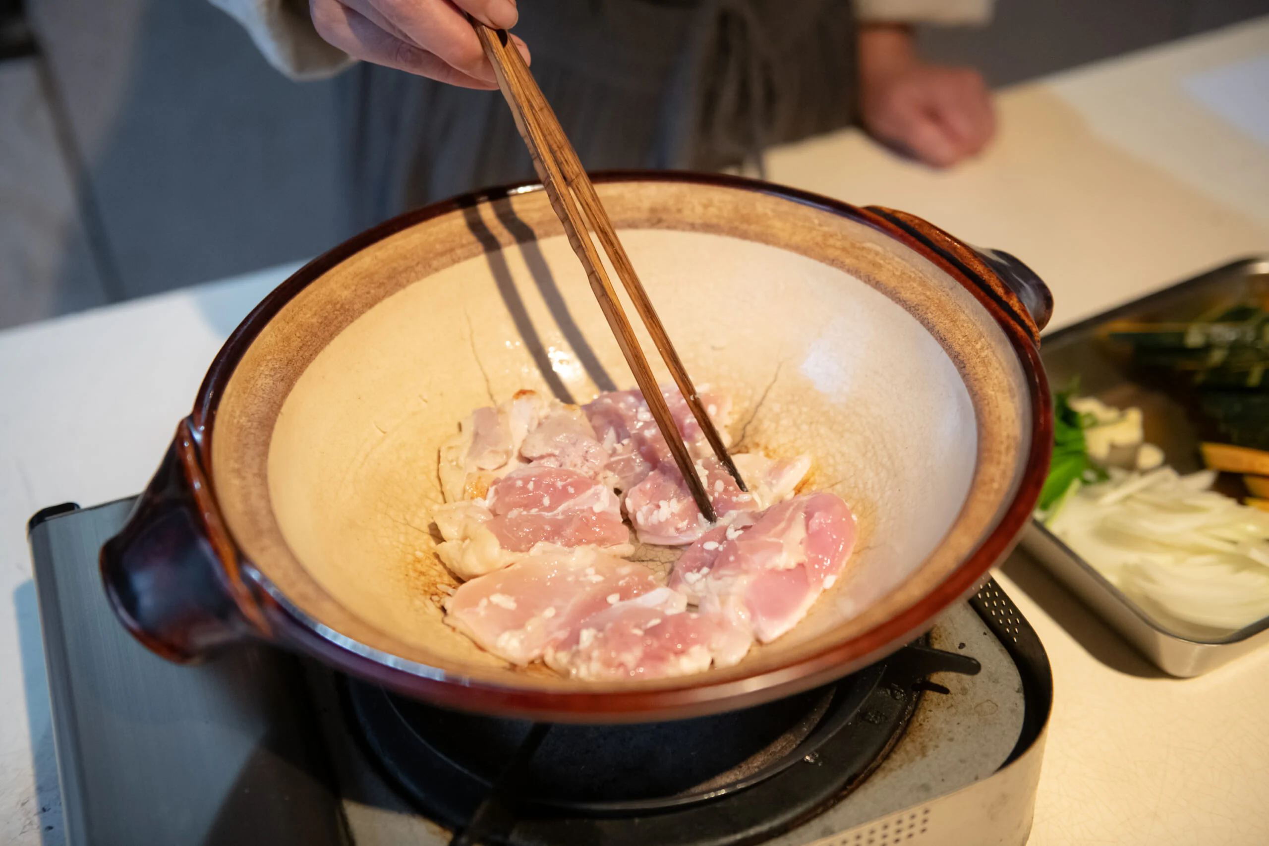 鍋を中火にかけて油を入れ、鶏肉の皮目を下にして並べます。皮に焼き色がつくまでしっかり焼きつけます。