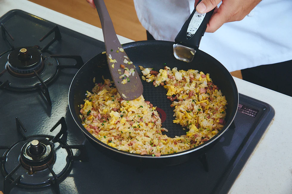 調味料、具材を入れてさらに炒める様子