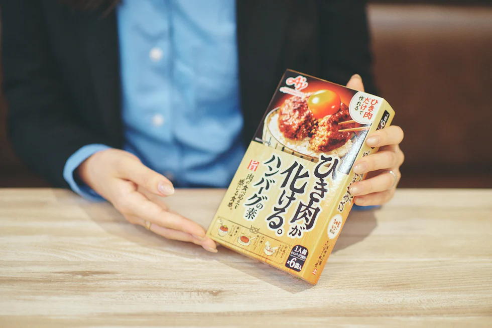 「ひき肉が化ける。®ハンバーグの素」を手にする様子