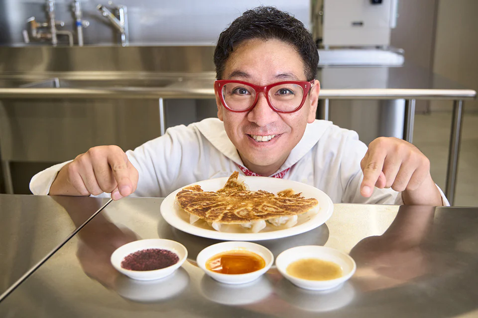 3種の餃子のタレを指差し、笑顔のクック井上。さん