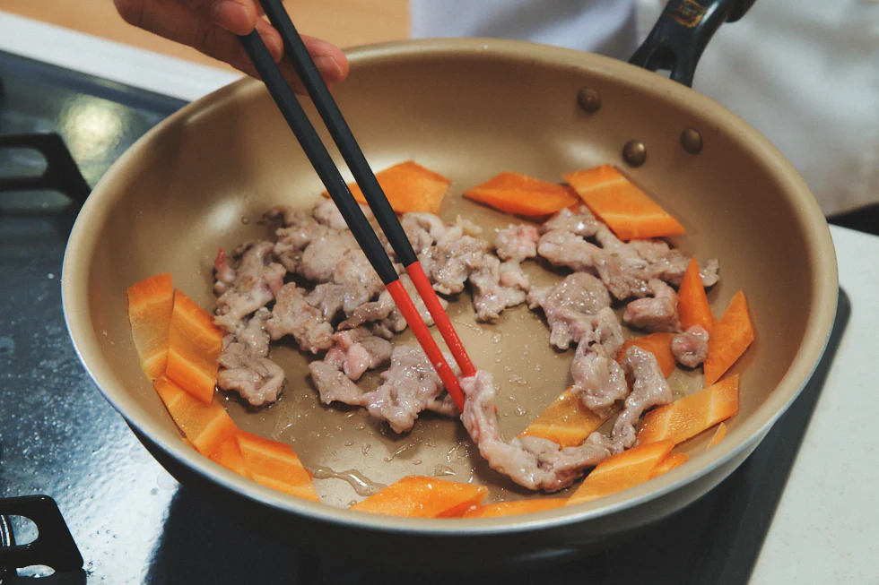 肉の表面が茶色くなったら、にんじんを入れる。このとき中弱火でゆっくり火を通すことがポイント。タンパク質は加熱温度が60℃に達するまでの時間がゆっくりであるほど、やわらかく仕上がる