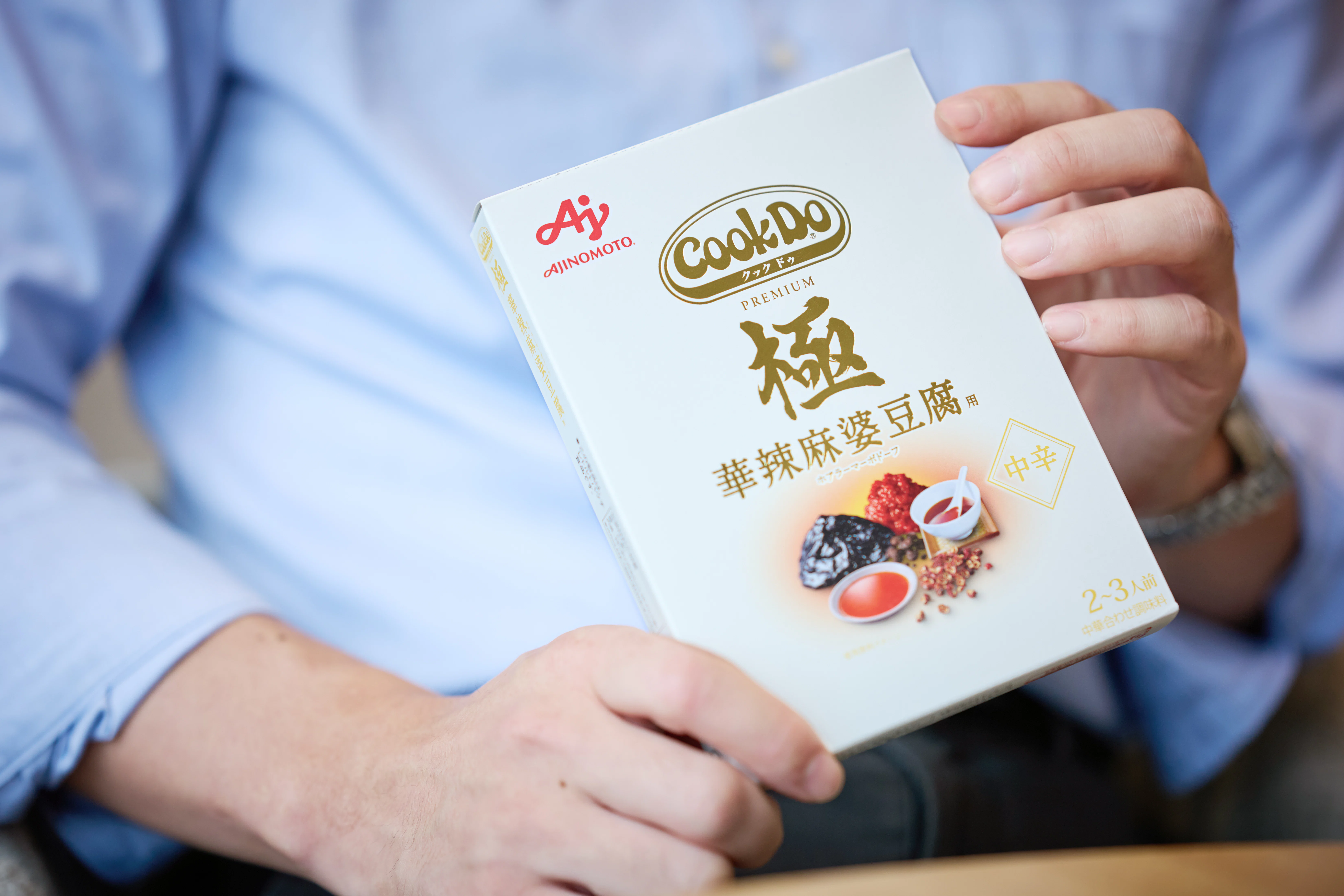 「Cook Do®」<極 華辣麻婆豆腐用>のパッケージを手に持っている様子