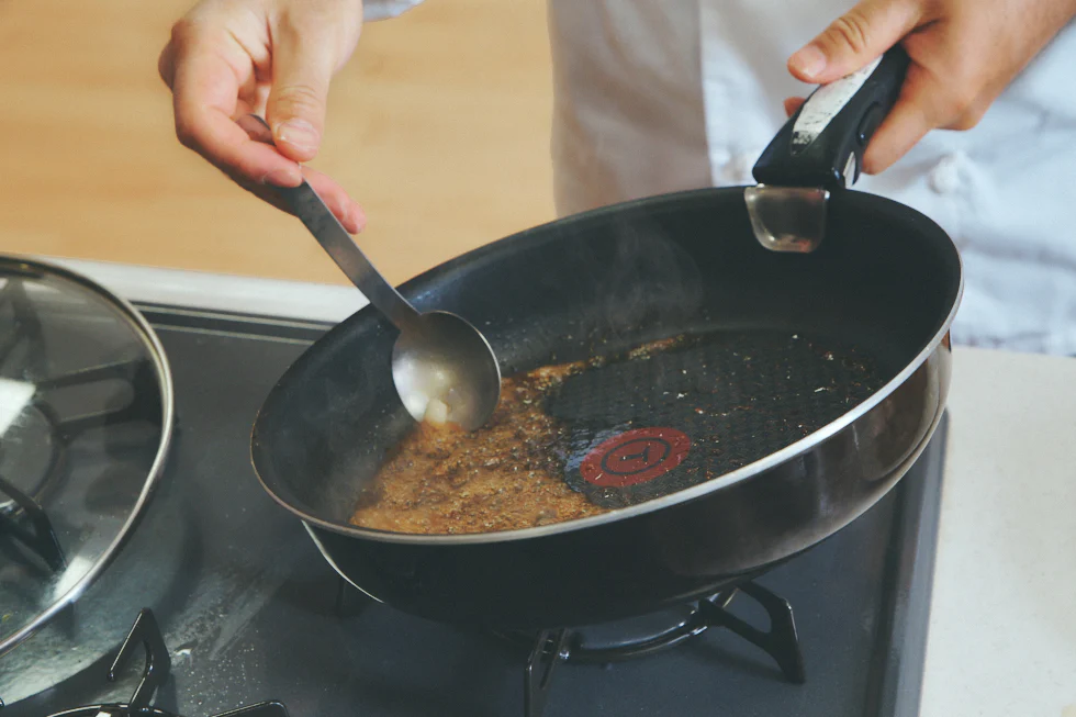 ソテーを調理した後のフライパンに、醤油・みりん・すりおろしにんにくを入れる