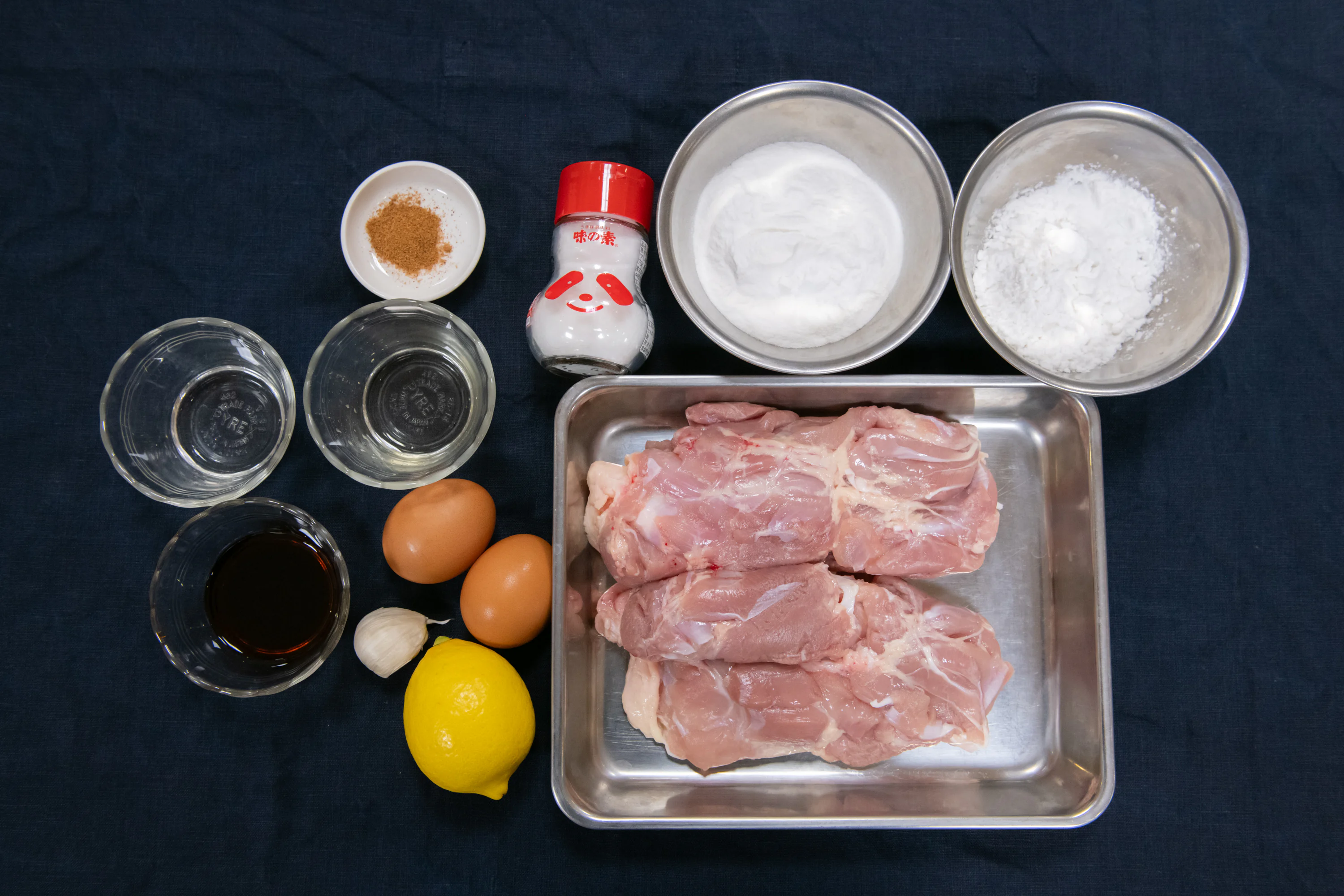 基本の材料は、鶏もも肉、しょうゆ、みりん、酒、にんにく、うま味調味料「味の素®」、ナツメグと、衣に使う米粉、片栗粉、卵。レモンは好みで最後に絞る。
