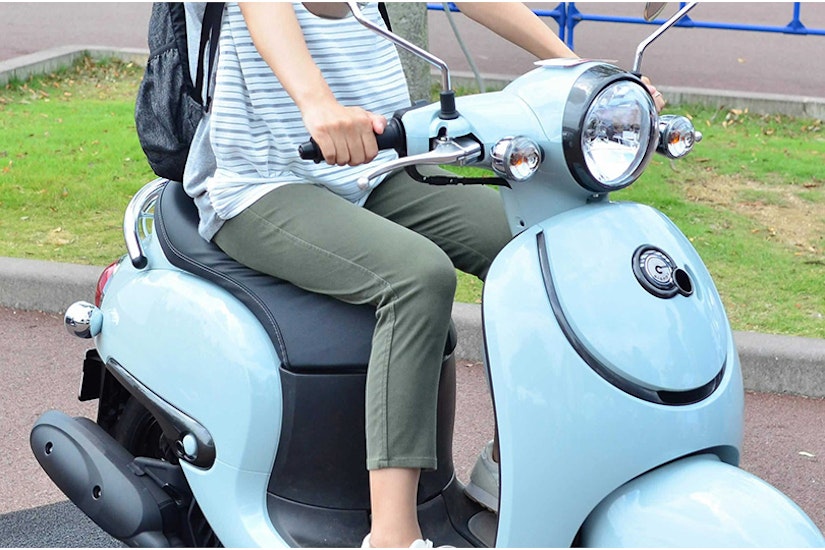 水色の原付バイクに乗る女性