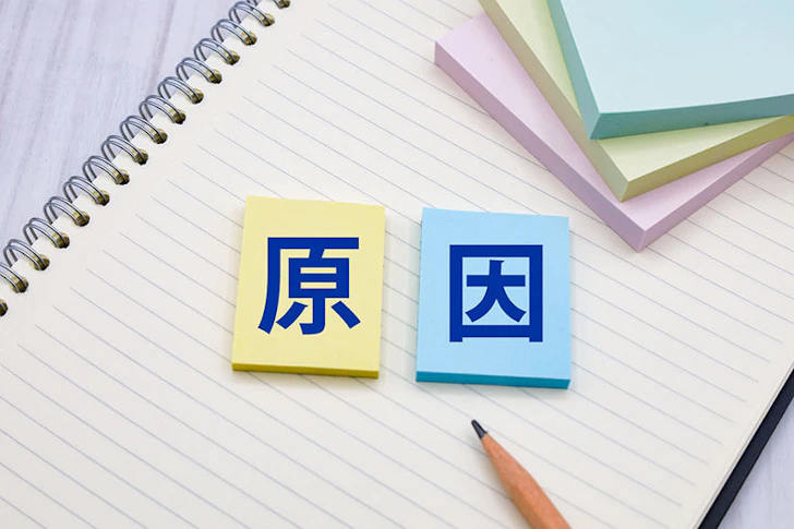 ノートの上に原因と書かれた付箋が置かれている