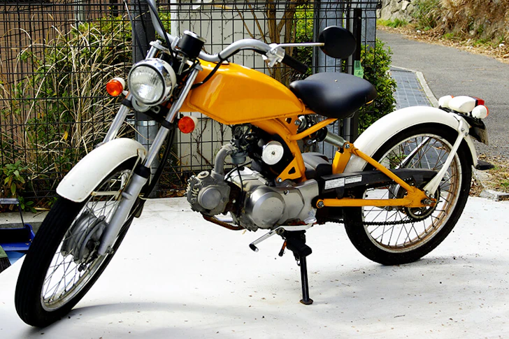 道に停められたオレンジと白のバイク