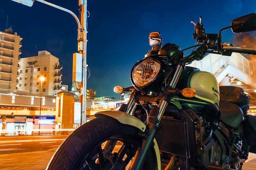 夜の道路に停められたバイク