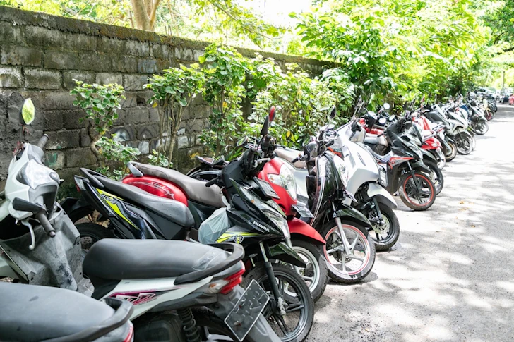 緑が広がる駐車場に多くのバイクが駐車されている。