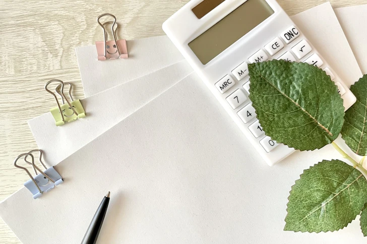 書類や電卓、ボールペンが置かれている。