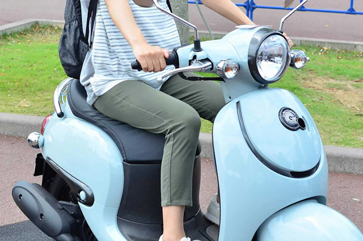 水色の原付に乗った女性