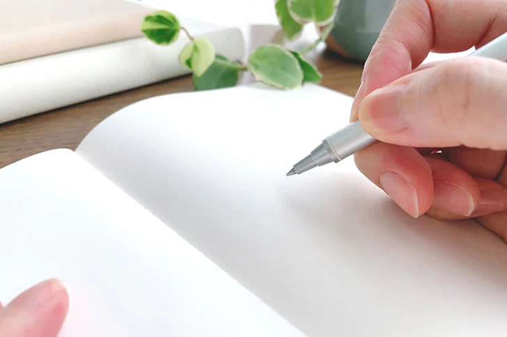 ノートにボールペンで書こうとしている手元