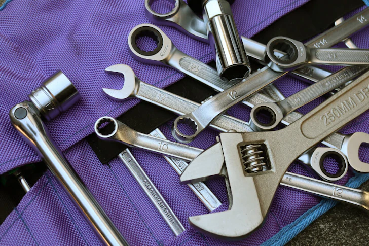 紫色の布の上にねじ回しなど多くの工具が置かれている