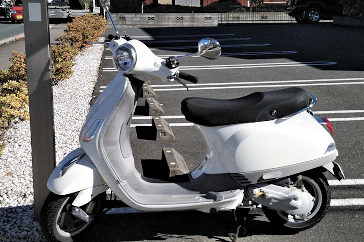白い原付バイクが駐車されている