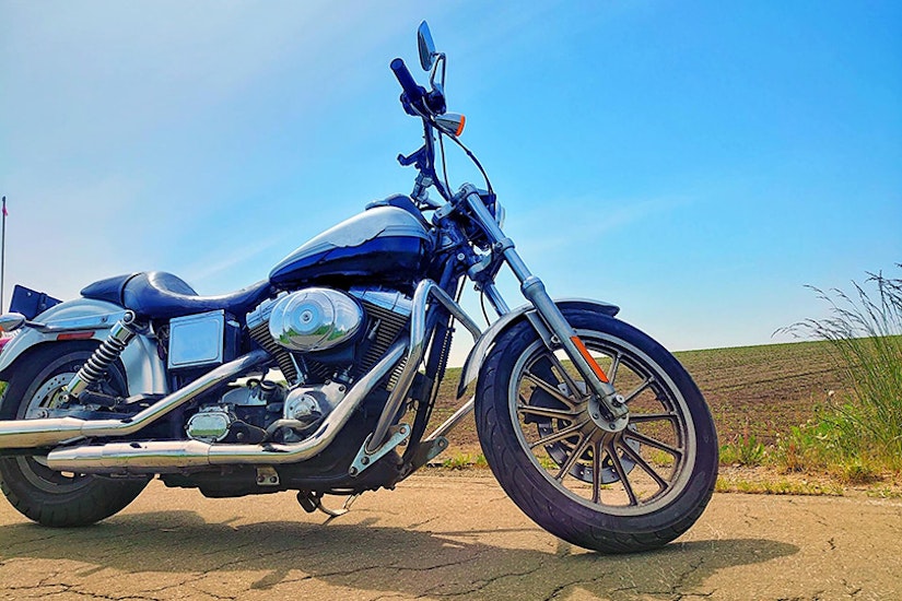 青いバイクの背景に青空が広がっている