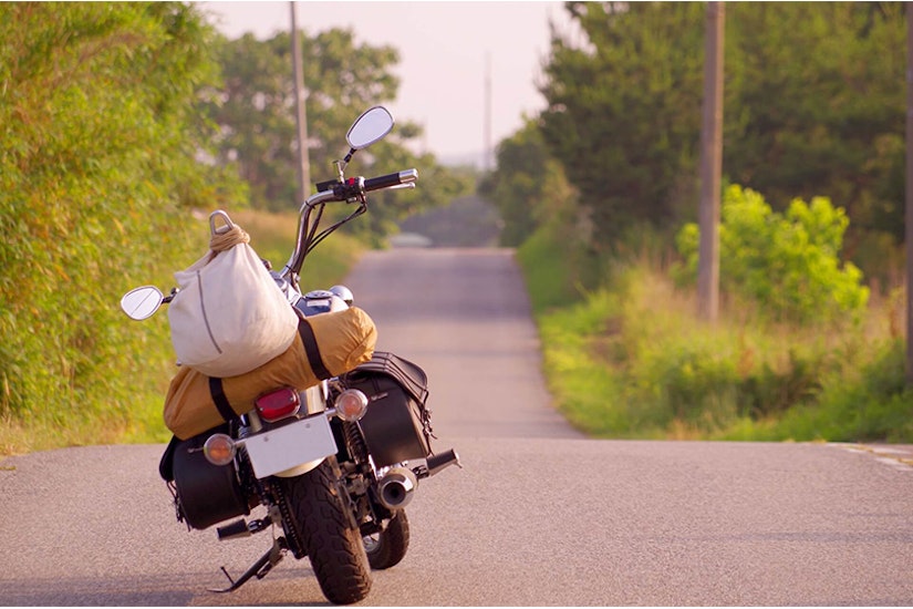 荷物が乗せられたバイクが道路に止まっている