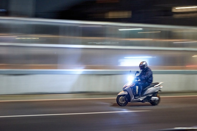 夜の高速道路で走行するバイク