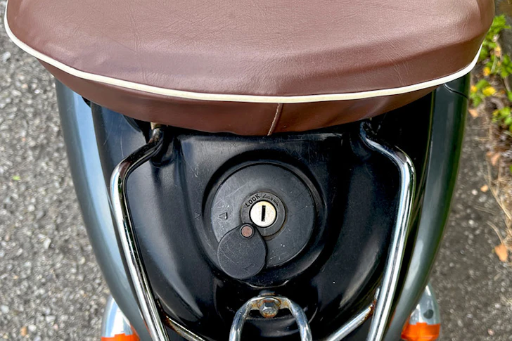 シート下に配置された原付バイクの給油口とキーシリンダー。