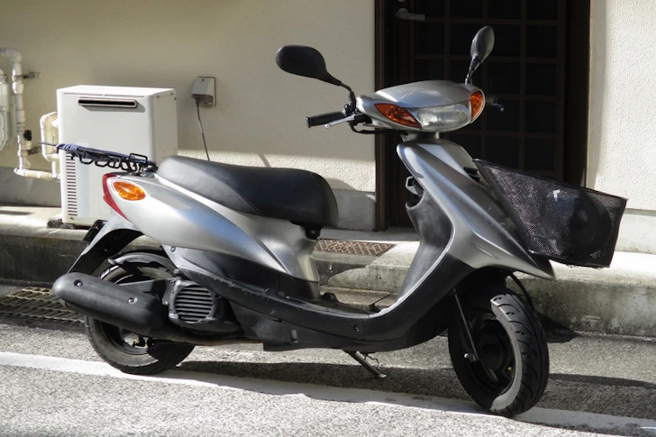 駐車されているシルバーの原付バイク