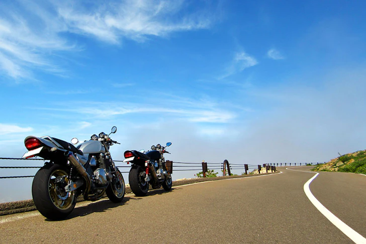 背景に青空が広がっている道路に並ぶバイク