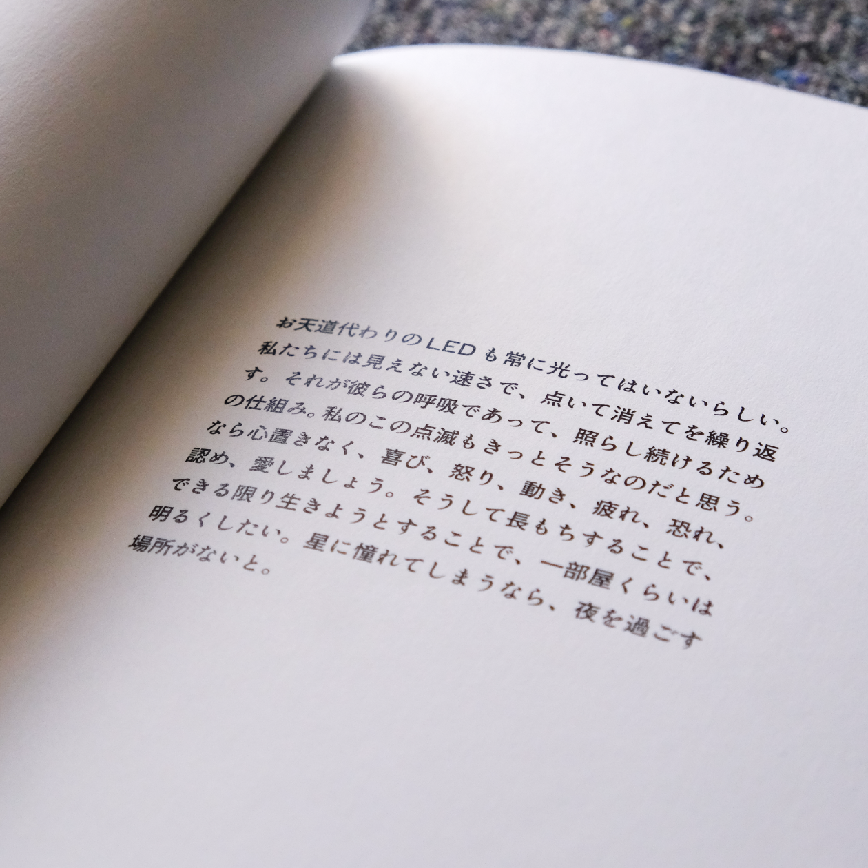 『星とフリッカー』3ページ目の画像。掲載されている文章「お天道代わりのLEDも常に光ってはいないらしい。私たちには見えない速さで、点いて消えてを繰り返す。それが彼らの呼吸であって、照らし続けるための仕組み。私のこの点滅もきっとそうなのだと思う。なら心置きなく、喜び、怒り、動き、疲れ、恐れ、認め、愛しましょう。そうして長もちすることで、できる限り生きようとすることで、一部屋くらいは明るくしたい。星に憧れてしまうなら、夜を過ごす場所がないと」。