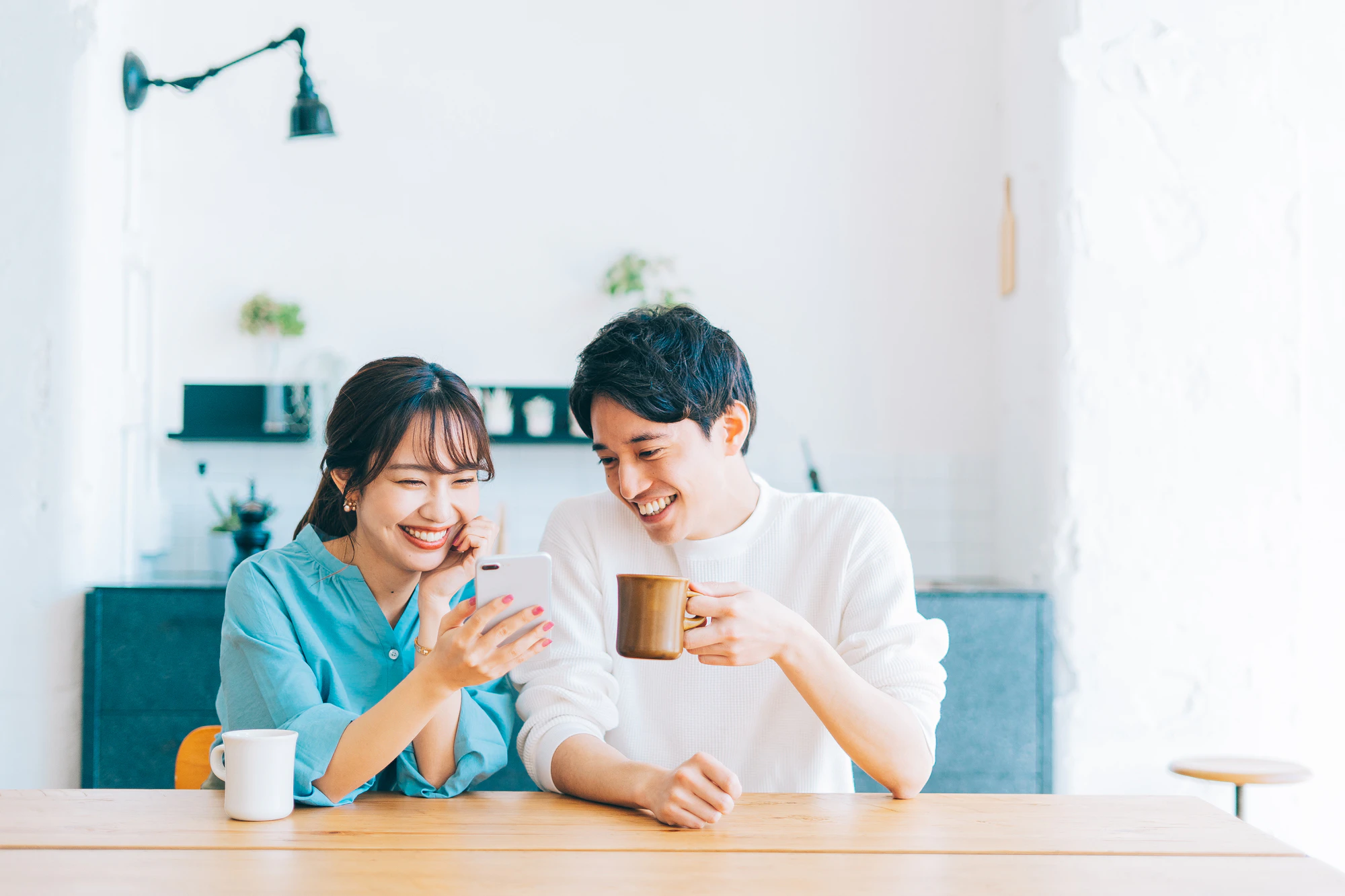 一緒にスマホを見る若い夫婦 カップル