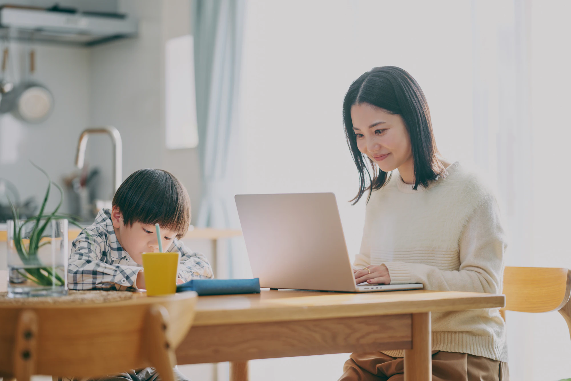 勉強する子供とリモートワーク中の親