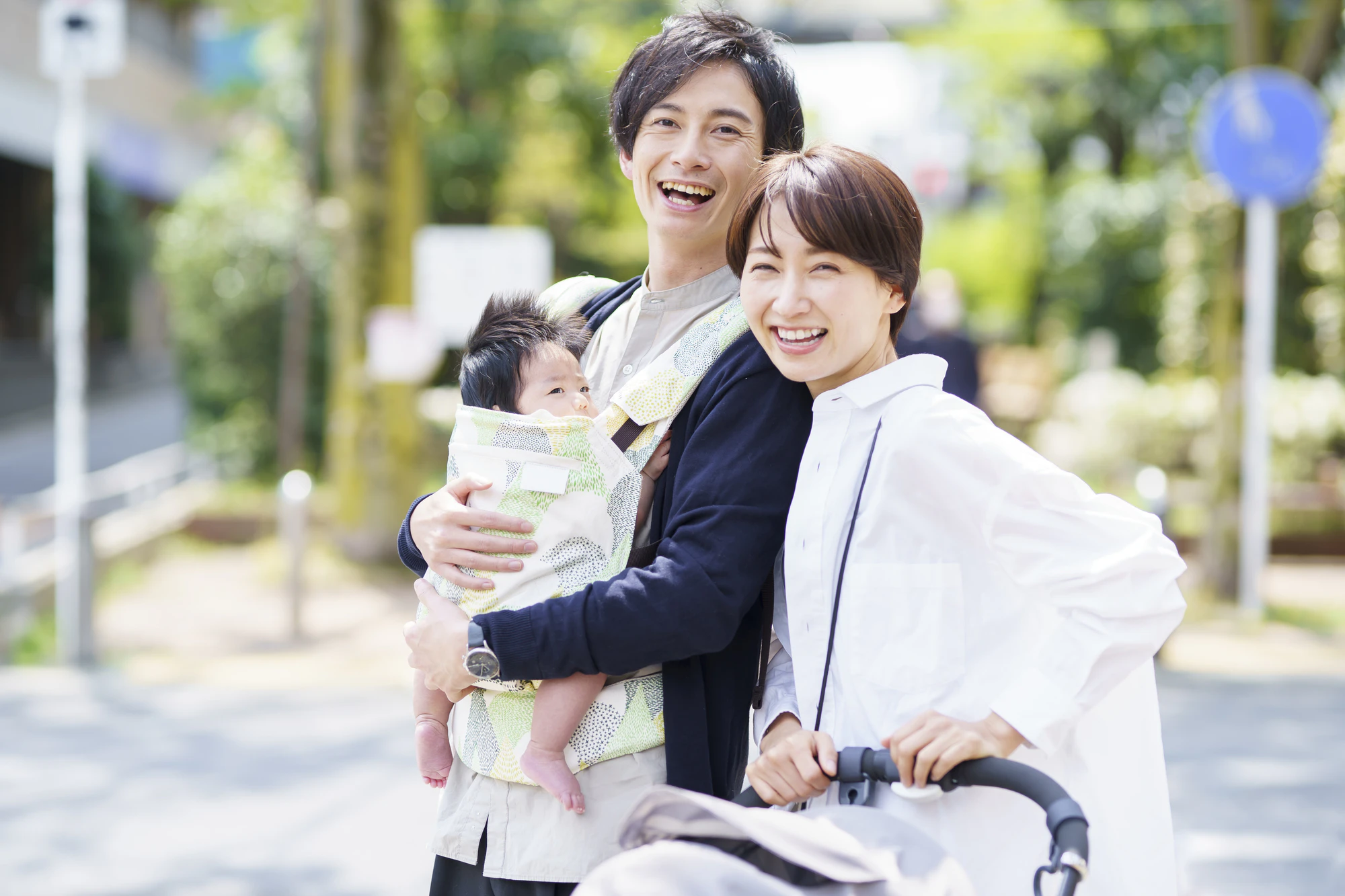  生後三ヶ月の赤ちゃんと散歩する父母