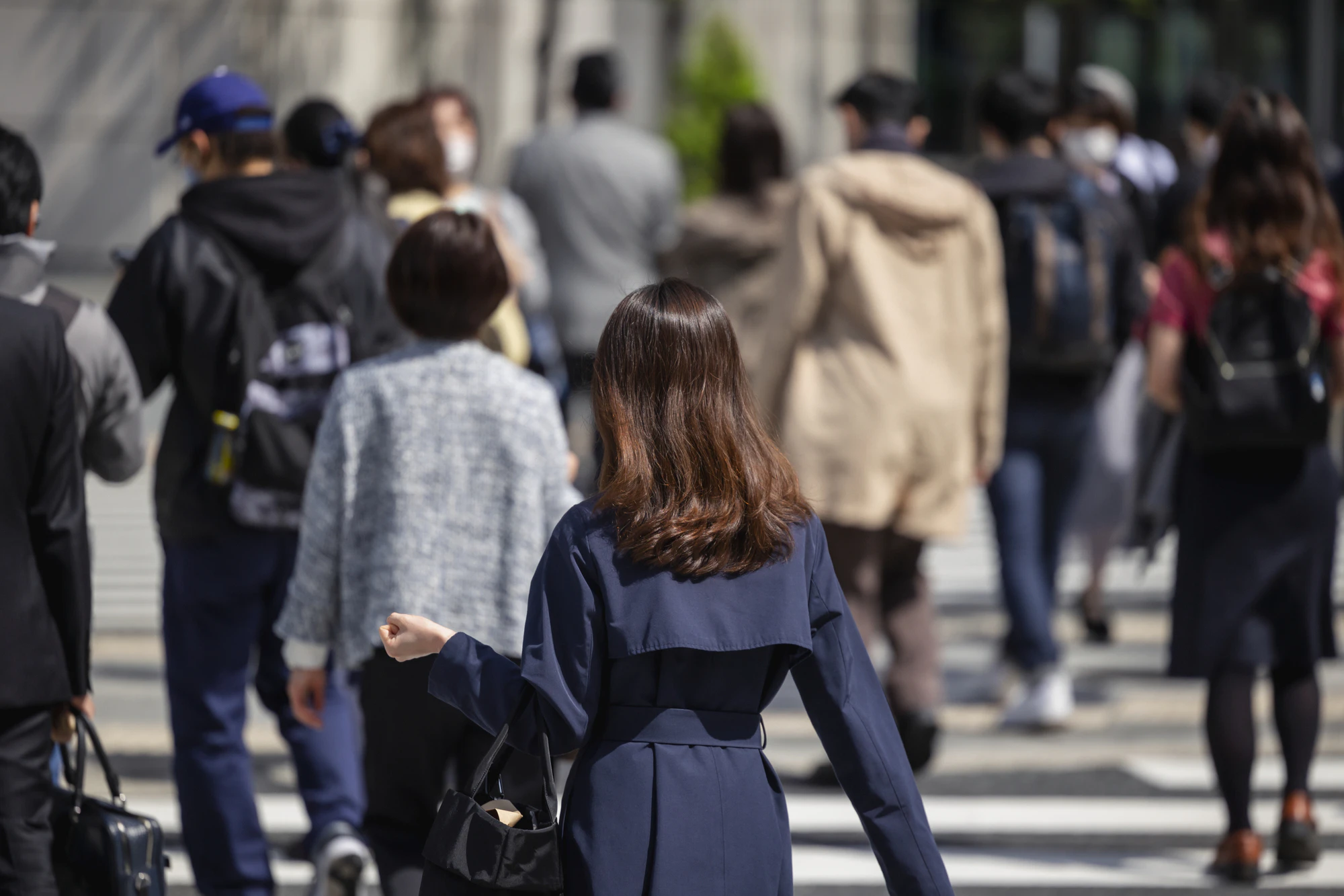 朝の通勤をする歩く女性の後ろ姿