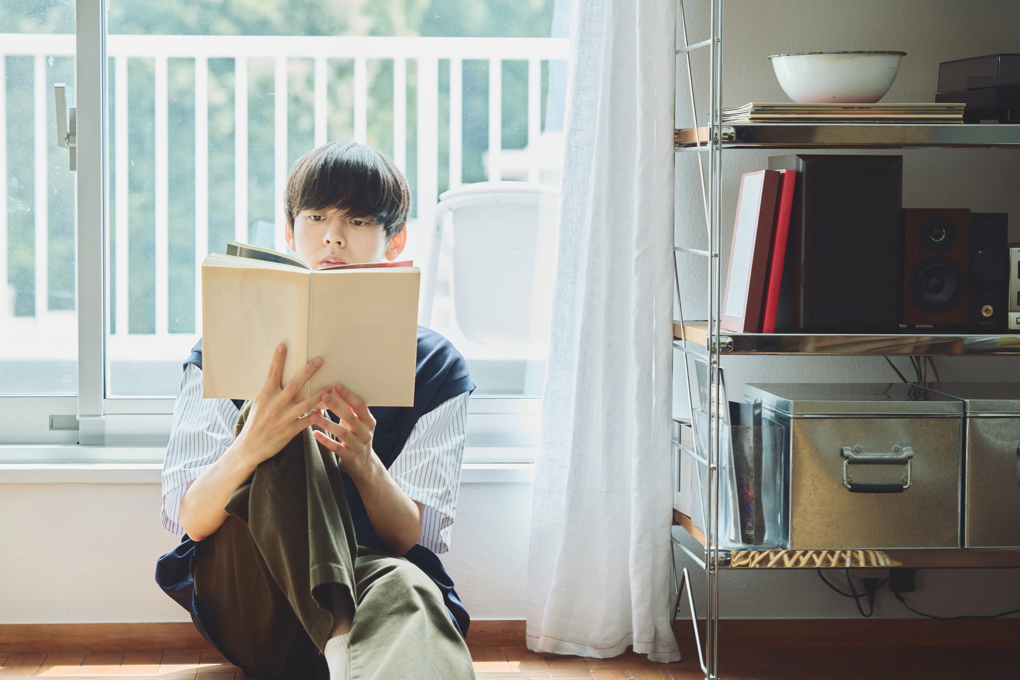 窓辺で読書する男性