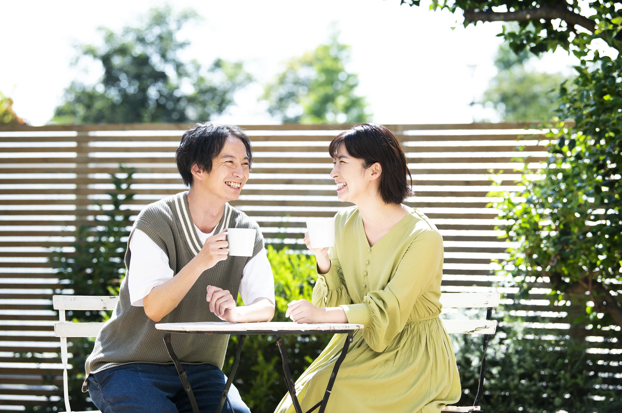 テラスでコーヒーを飲む若い夫婦