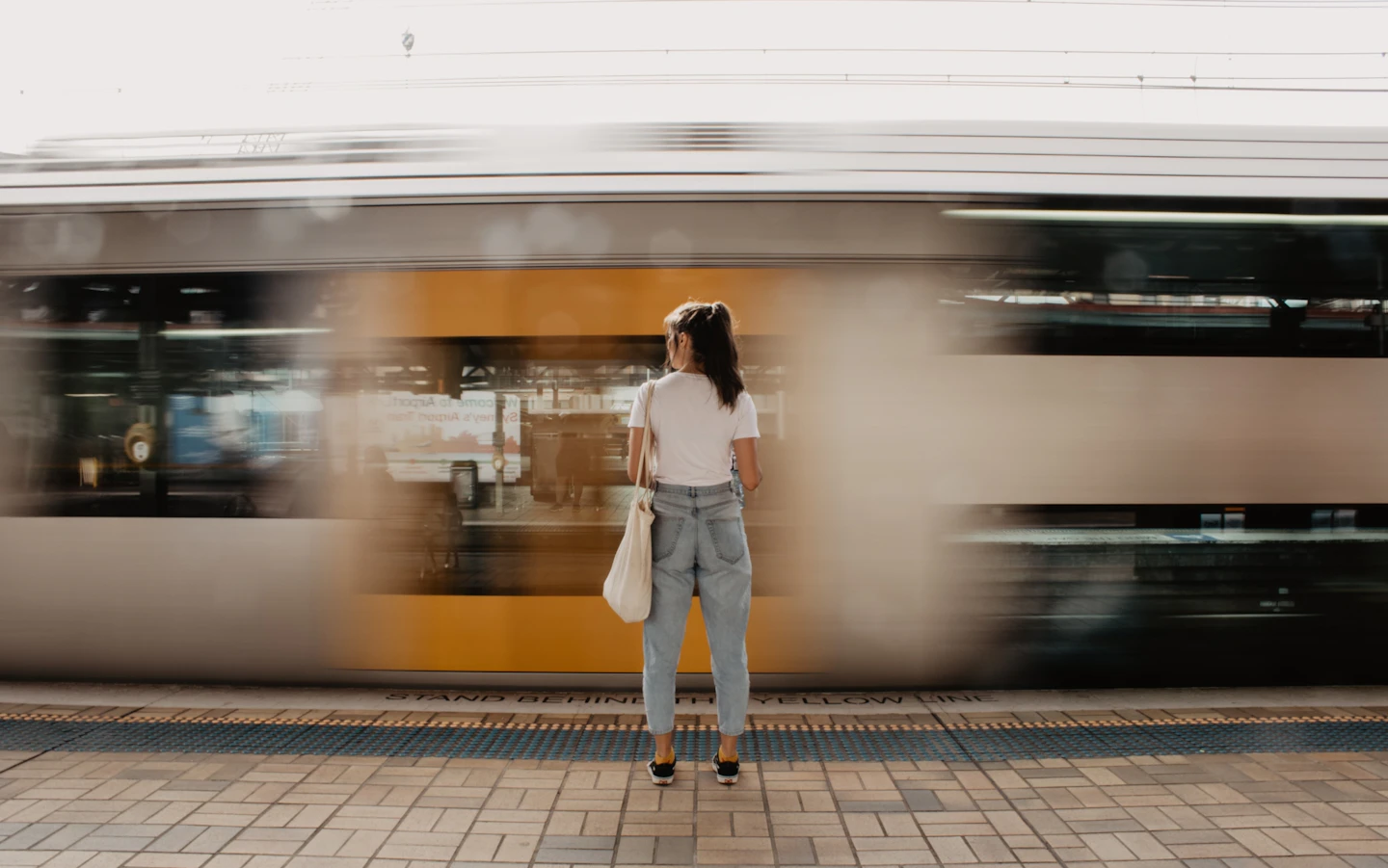 駅のホームに立つ女性