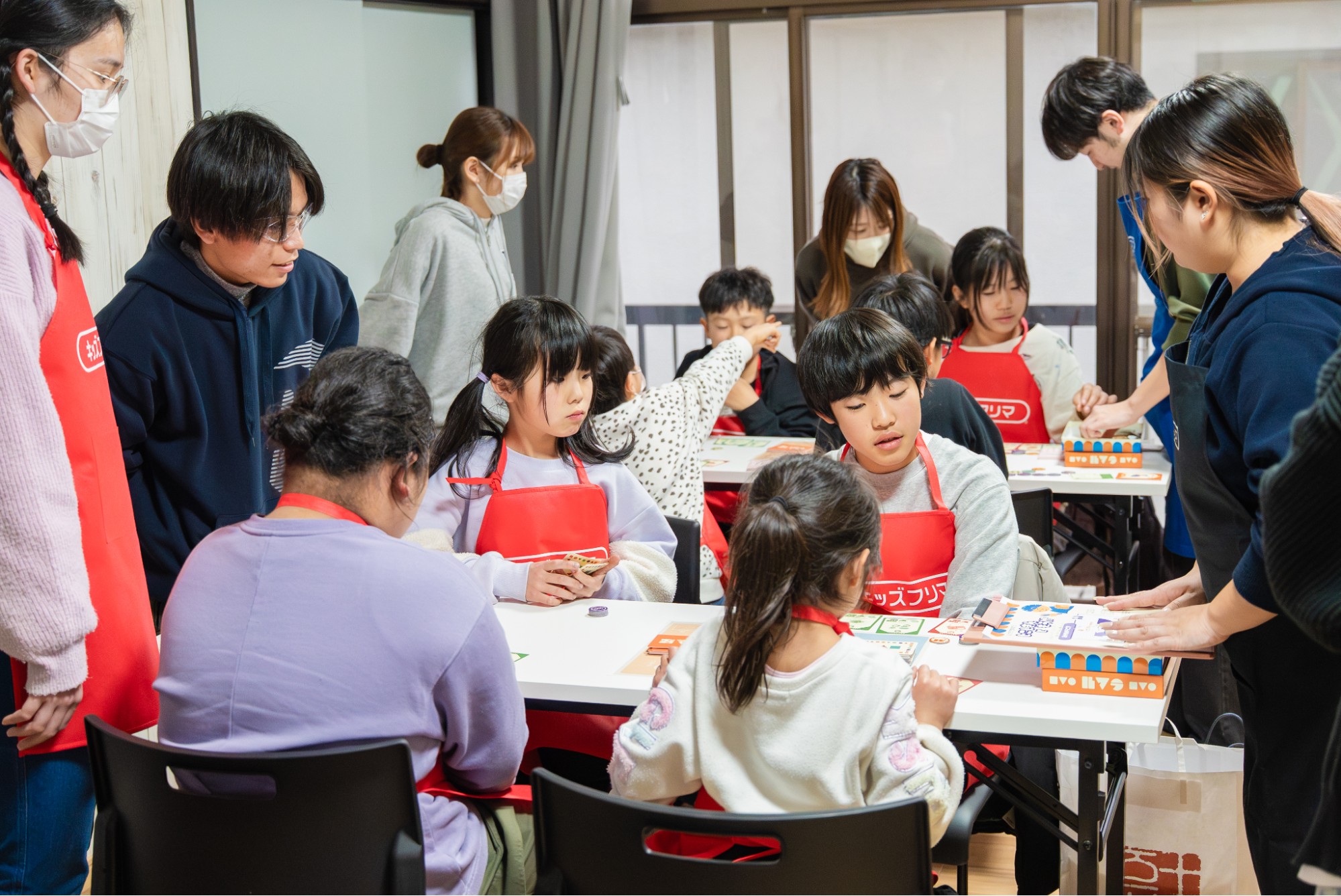 NPO法人キッズフリマのイベントで大人と子どもがワークショップに取り組む写真