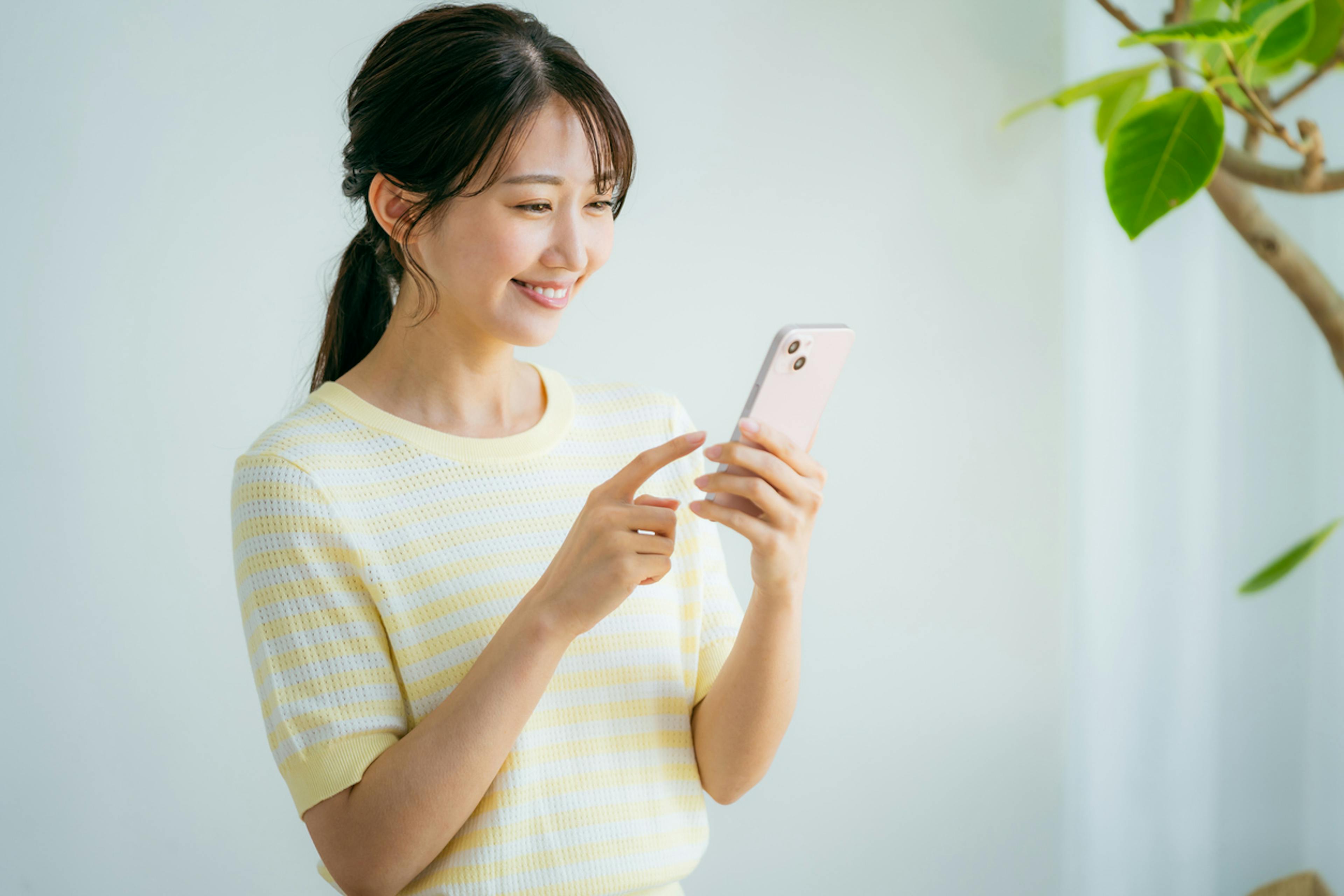 スマホで女性医療保険を探す女性