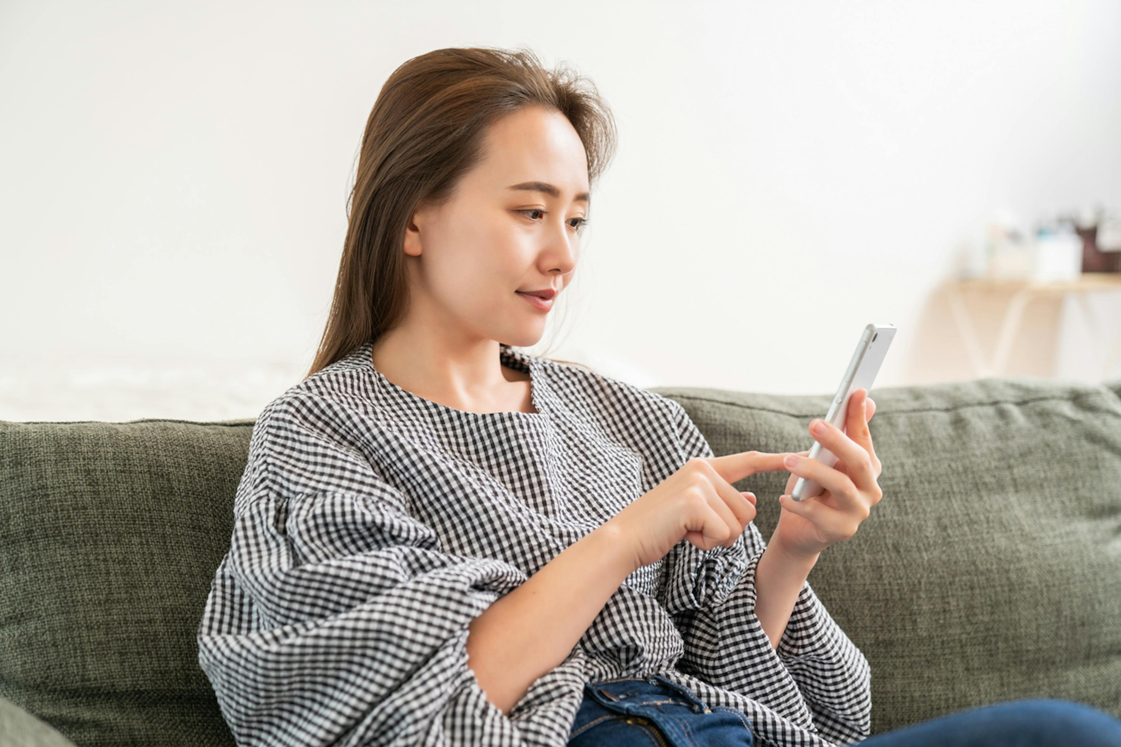 スマホで生命保険を比較している女性