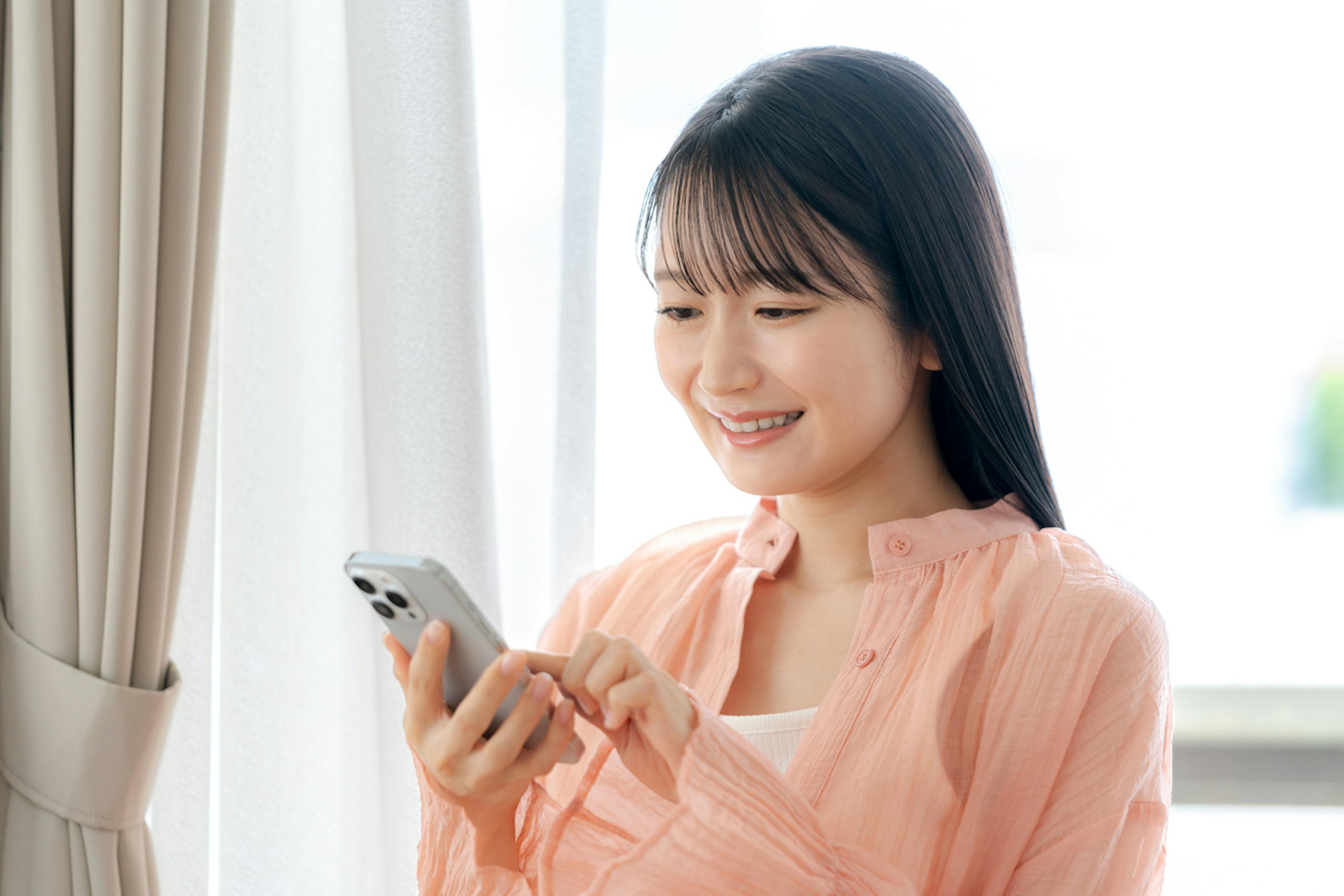 スマホでバセドウ病でも入れる生命保険を探す女性