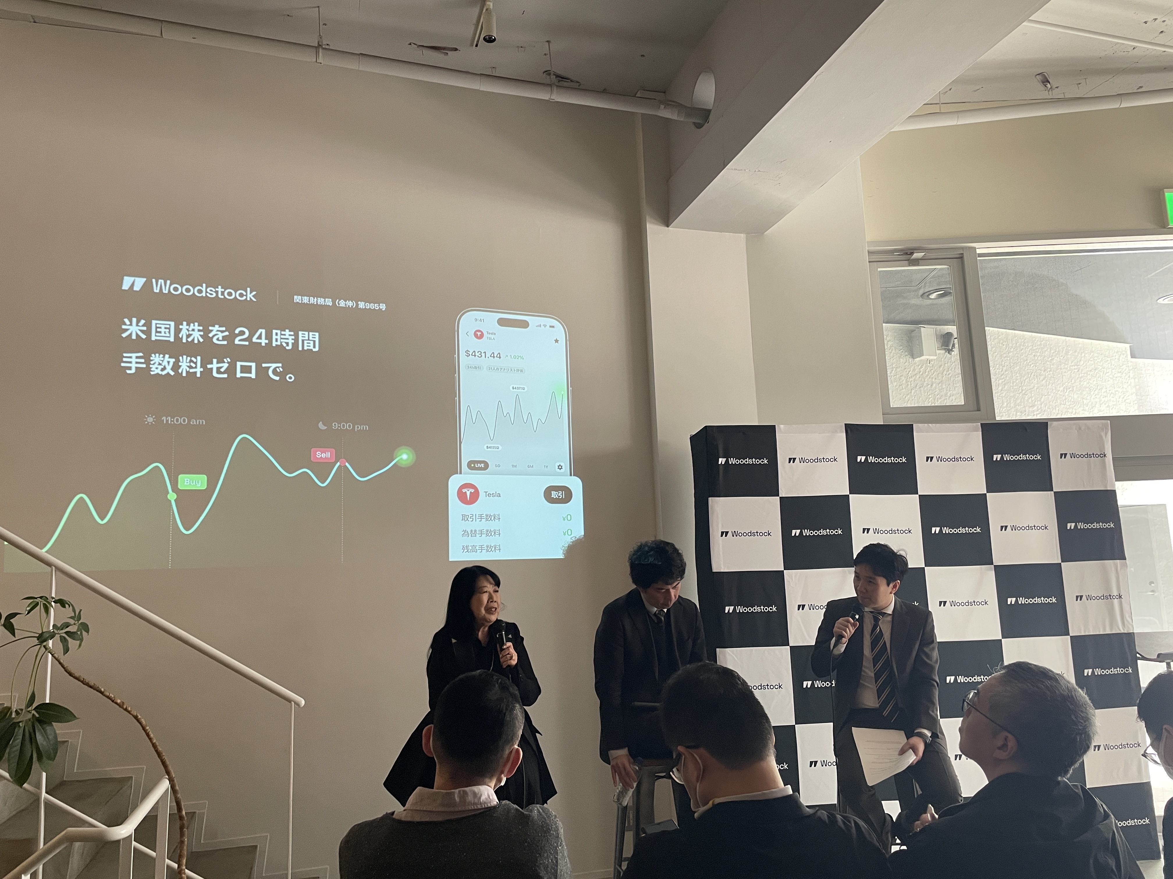 Woodstock主催の投資イベントで行われたパネルディスカッション。米国株24時間取引と手数料ゼロを紹介するスライドを背景に登壇者が対談している。