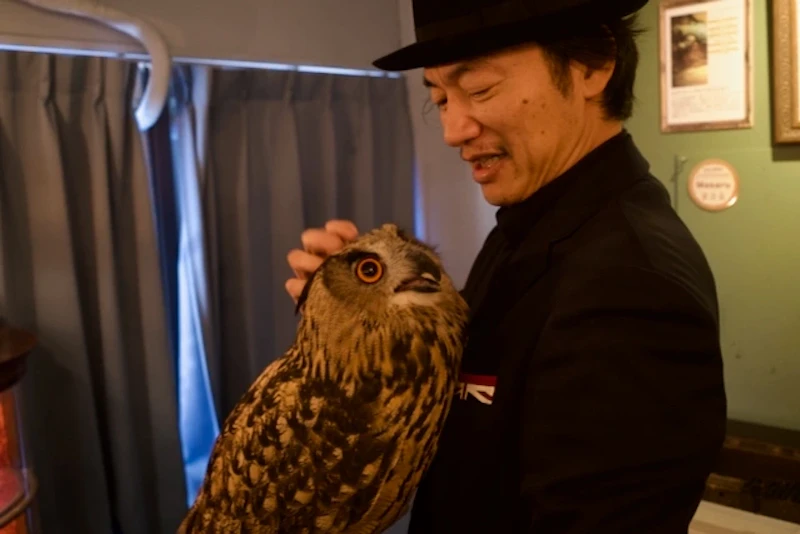 ユーラシアワシミミズクのまさるを撫でる土橋さん