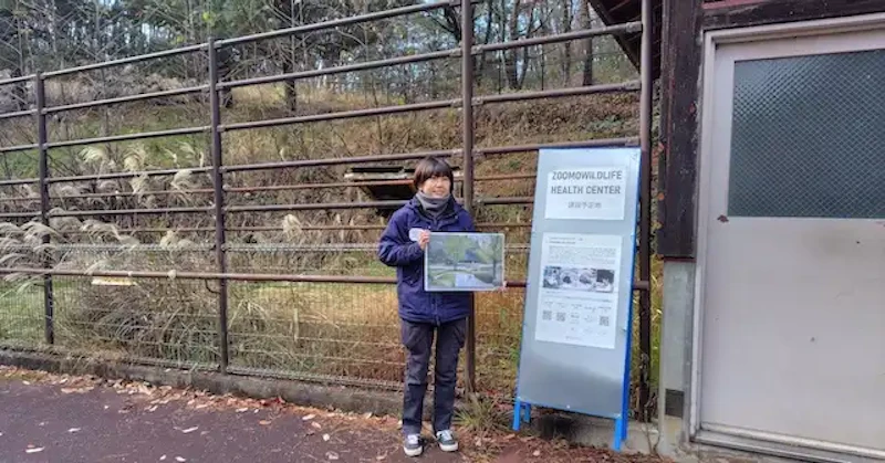 動物病院の建設予定候補地でイメージ図を掲げる松原 獣医師