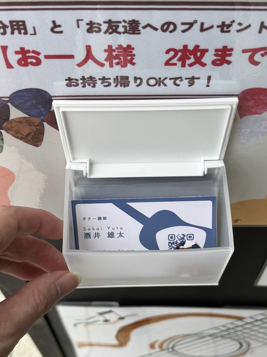 看板に設置された無料ピックと名刺入りのケース