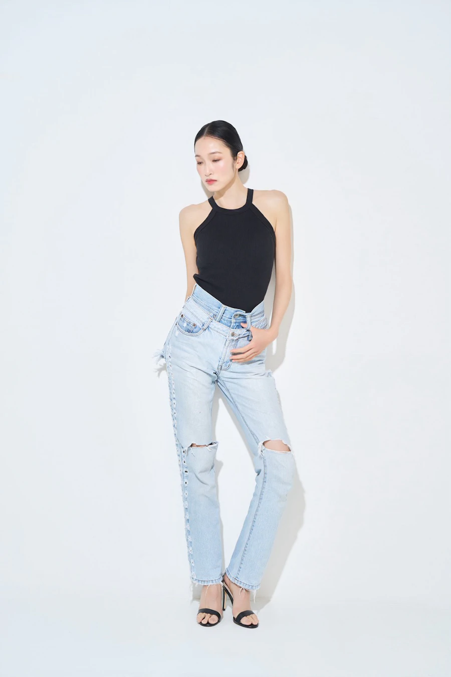 白背景で黒いトップスとデニムを着た女性の全身プロフィール写真
