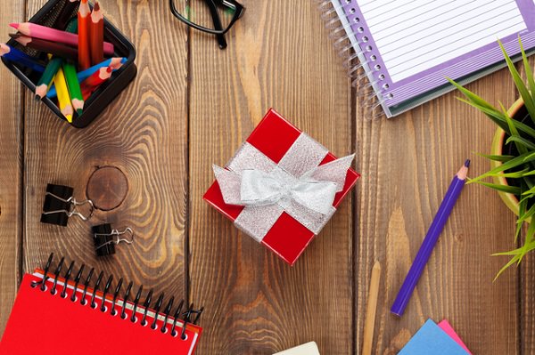 Red gift box and office supplies over office table